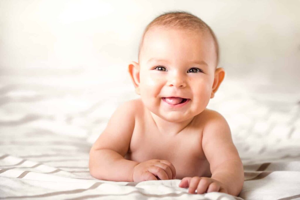baby i 2. tigerspring ligger på en seng og smiler