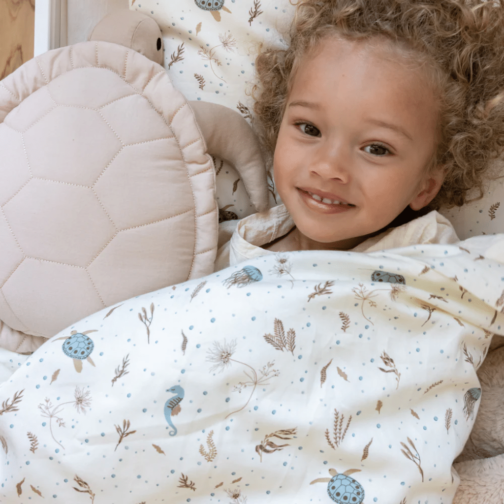 a child lying in a crib Cam cam Sengetøj, Junior, 100x140cm - GOTS sea garden
