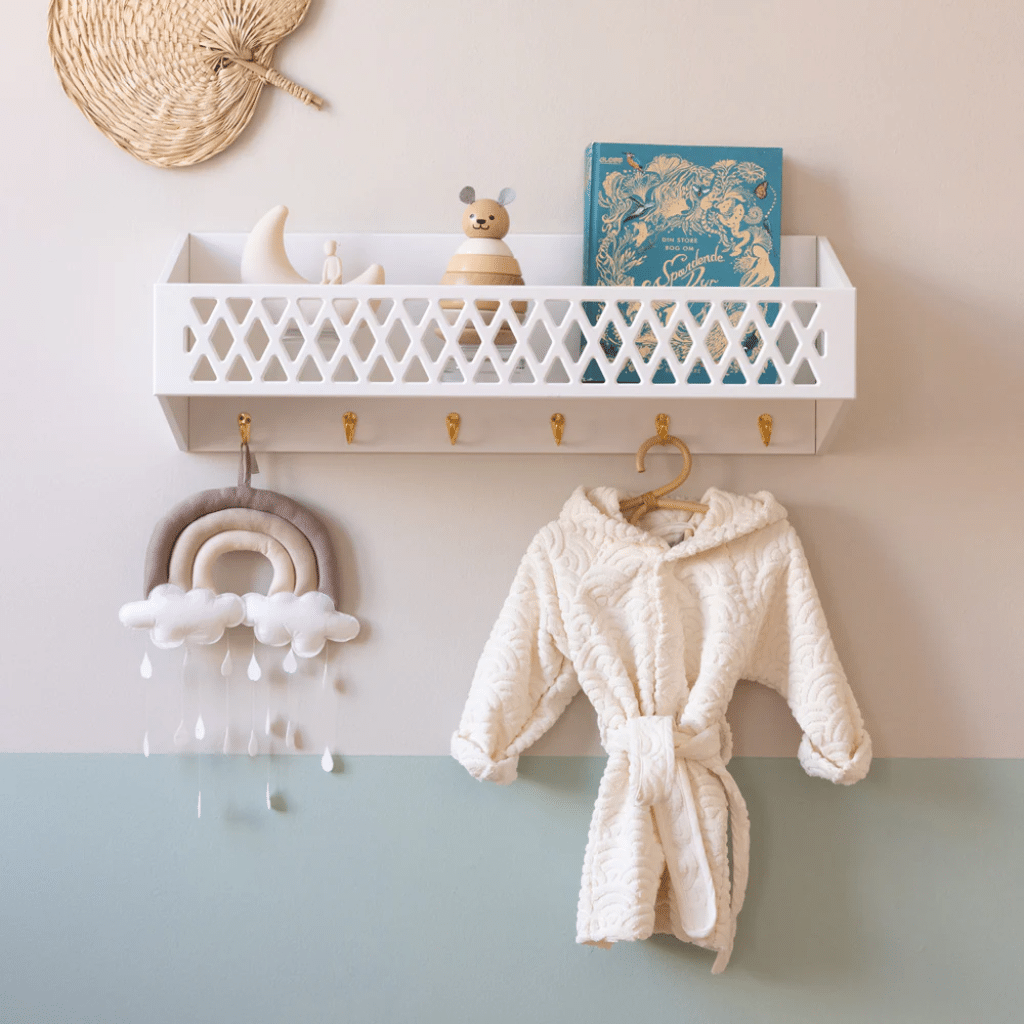 a shelf with toys and a white robe on a wall. cam cam Harlequin Hylde med knager, FSC Mix - Hvid