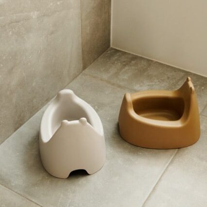a white and brown potty on a tile floor